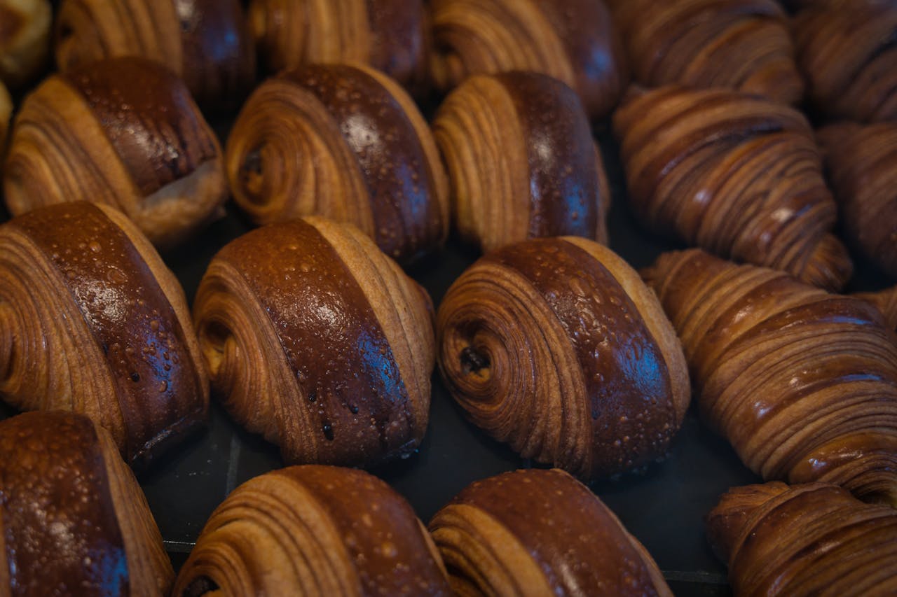 A close-up of fresh, golden brown artisan pastries in a Berlin bakery, showcasing intricate layers.
